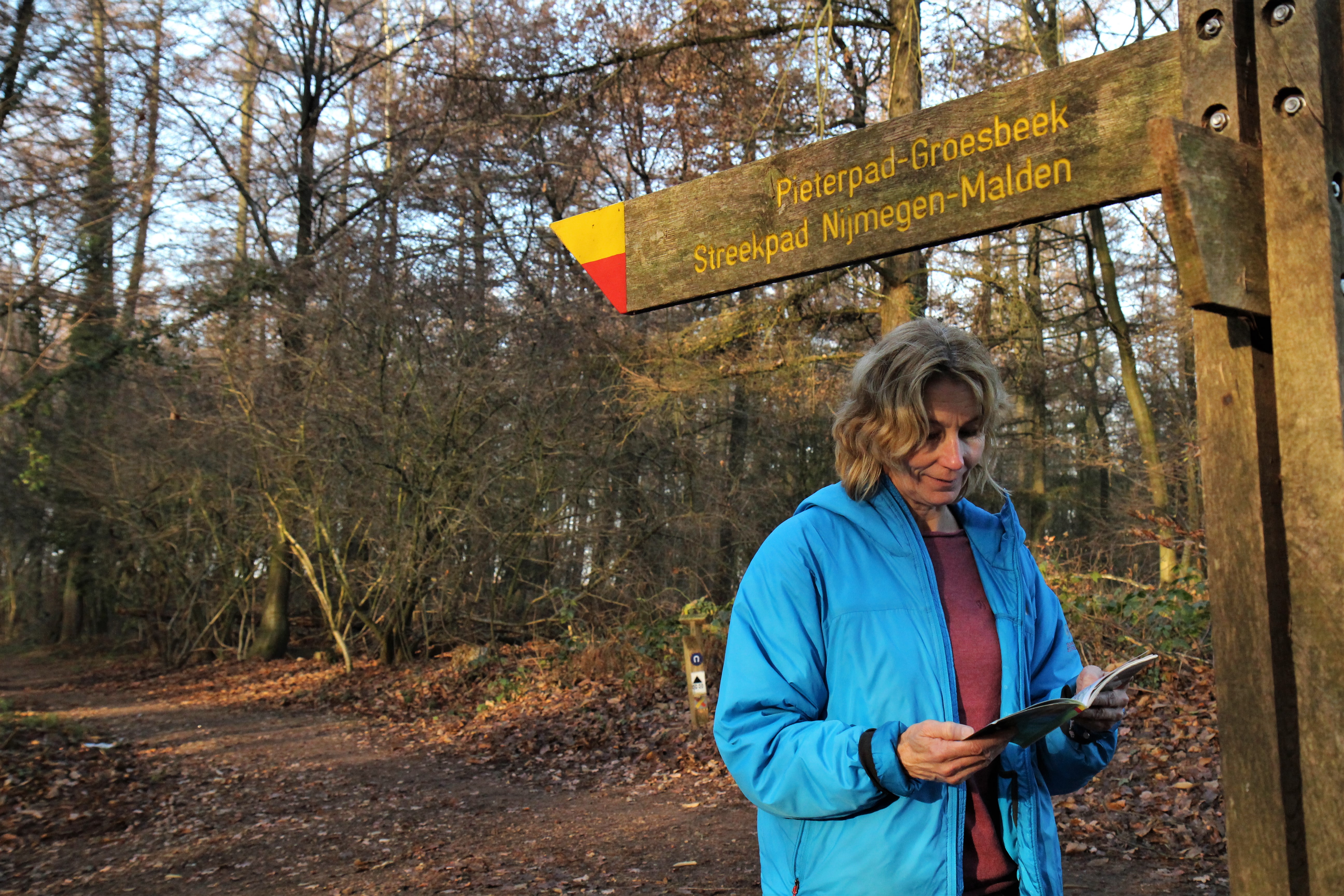 Wandelaar bij een wegwijzer met geel-rode markering © Luuk Gijselhart.JPG